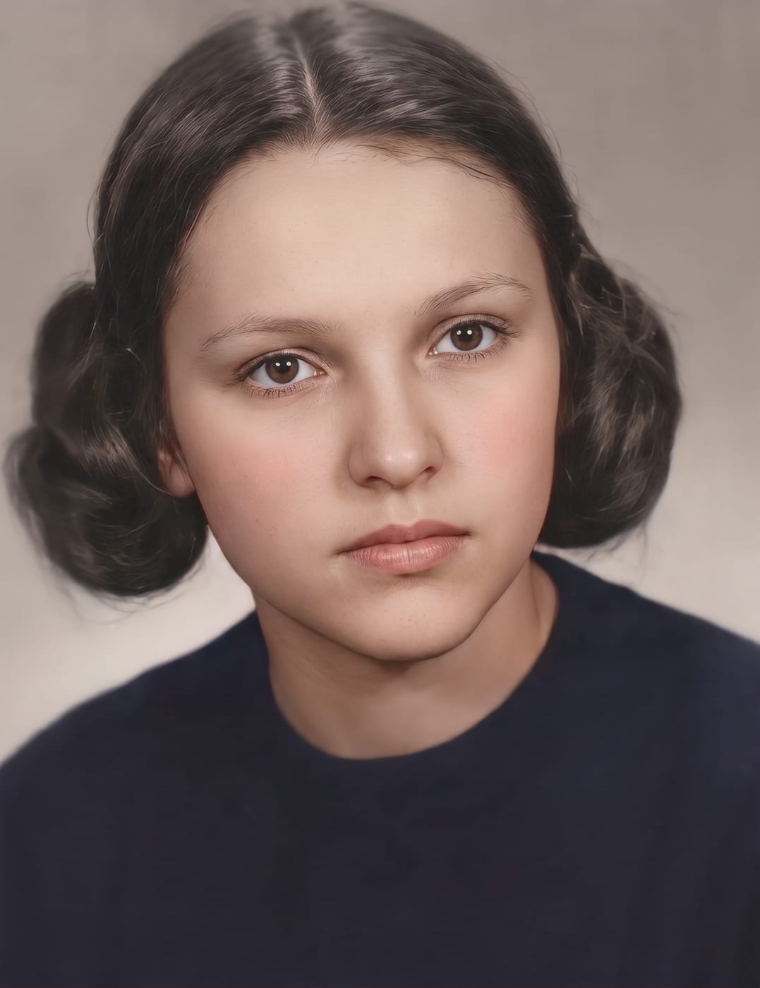 Restored and colorized 1940s studio portrait of a young woman with rolled hair and a dark top